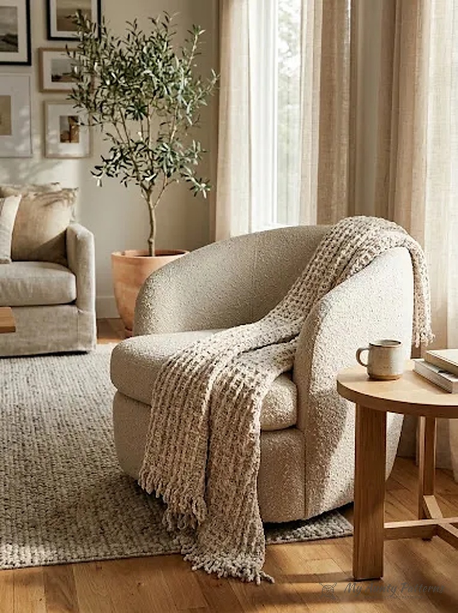 Finished cream and oatmeal crushed velvet chunky waffle and fringe crochet blanket draped over a cozy bouclé armchair in a sunlit living room